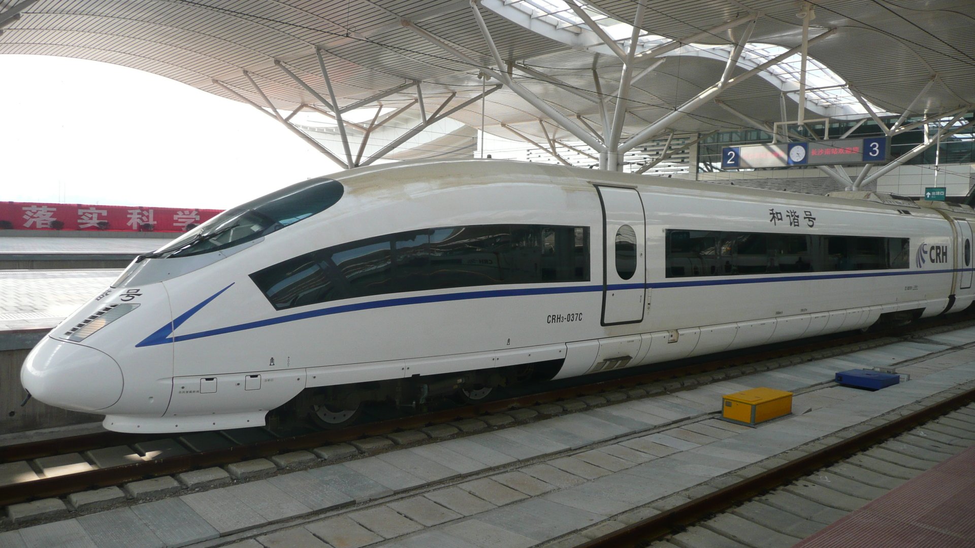 HD desktop wallpaper featuring a sleek, modern high-speed train at a spacious, well-lit station platform.