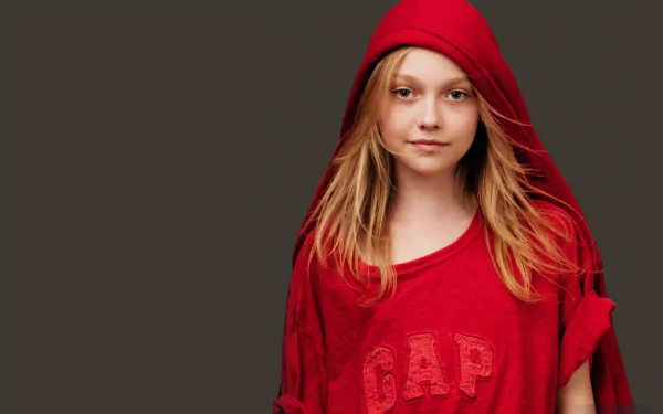A striking HD wallpaper featuring Dakota Fanning, an American actress, wearing a red hoodie, exuding a confident and youthful vibe against a simple gray background.
