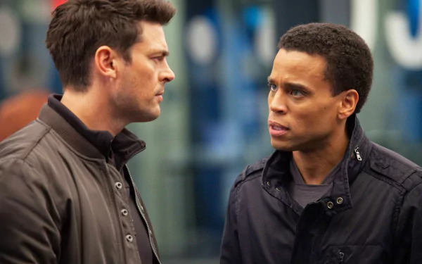 HD desktop wallpaper featuring Karl Urban from the TV series Almost Human, depicting an intense conversation between two characters.