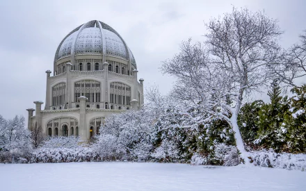 HD desktop wallpaper of a snow-covered Baha'i Temple surrounded by frosted trees under a pale winter sky.