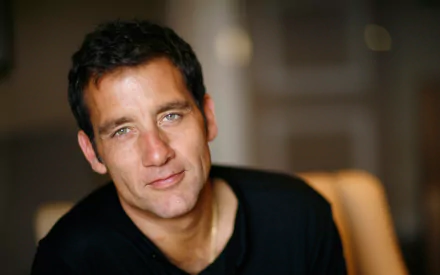 HD desktop wallpaper featuring English actor Clive Owen with a soft-focus background.