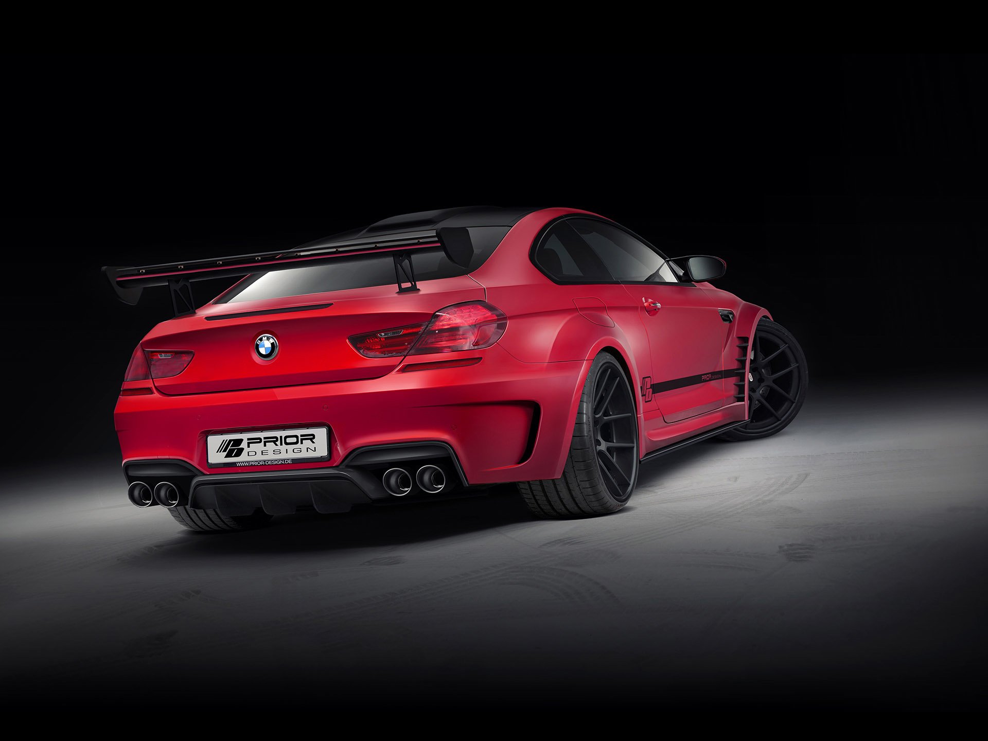 HD desktop wallpaper featuring a red Prior Design BMW M6 with sleek body modifications and black accents against a dark background.