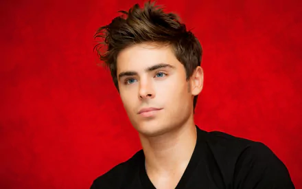 HD desktop wallpaper featuring American actor and celebrity Zac Efron against a vibrant red background.