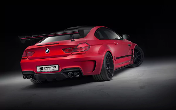 HD desktop wallpaper featuring a red Prior Design BMW M6 with sleek body modifications and black accents against a dark background.