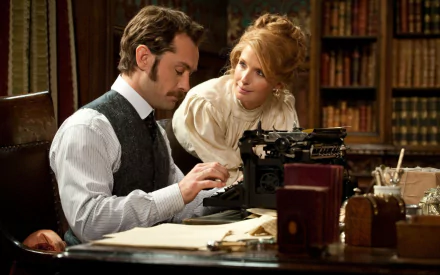 A scene from Sherlock Holmes: A Game of Shadows, featuring a man in period attire focused on a typewriter, while a woman in Victorian dress watches attentively in an elegant room.