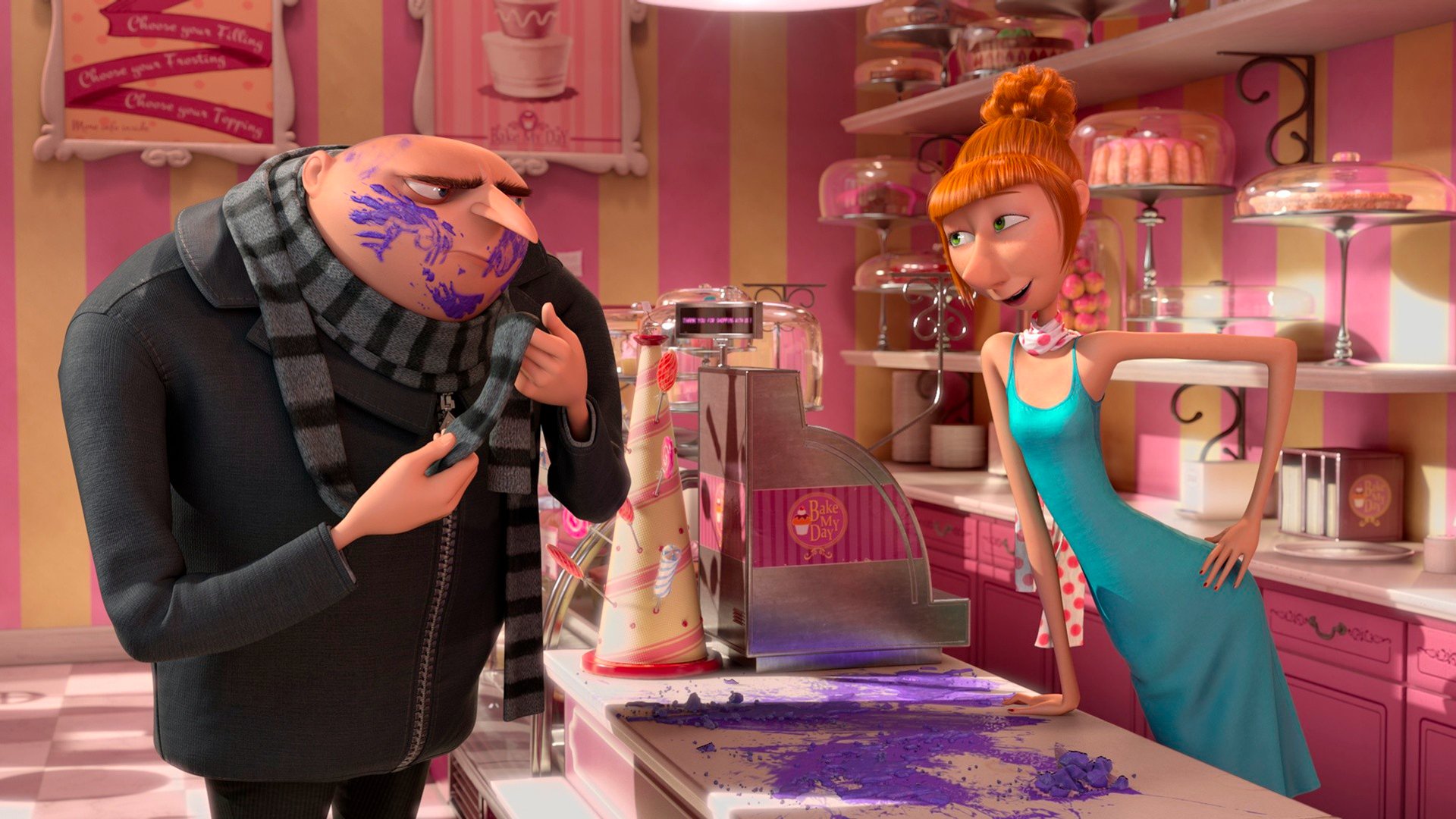 Lucy and Gru from Despicable Me 2 share a playful moment in a colorful bakery, surrounded by vibrant treats and a fun atmosphere in this HD desktop wallpaper.