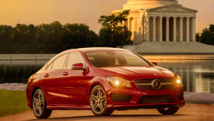 Red Mercedes-Benz CLA-Class sedan by a reflecting waterfront at sunset with a neoclassical monument — HD PC desktop wallpaper and background