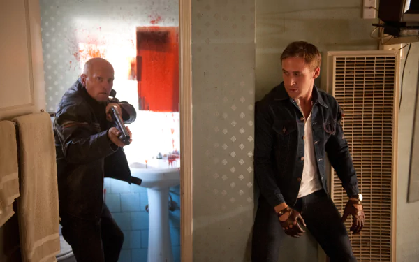 2K Quad HD PC wallpaper: tense film scene from Drive (2011) showing the Driver crouched by a heater with a pistol as a man bursts in aiming a shotgun.