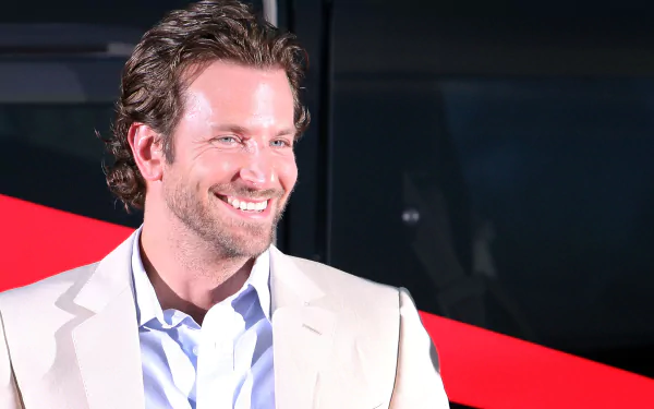 HD desktop wallpaper featuring American actor and celebrity Bradley Cooper smiling against a dark background with a red diagonal accent.