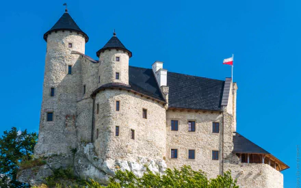 HD desktop wallpaper featuring the historic man-made Bobolice Castle under a clear blue sky.