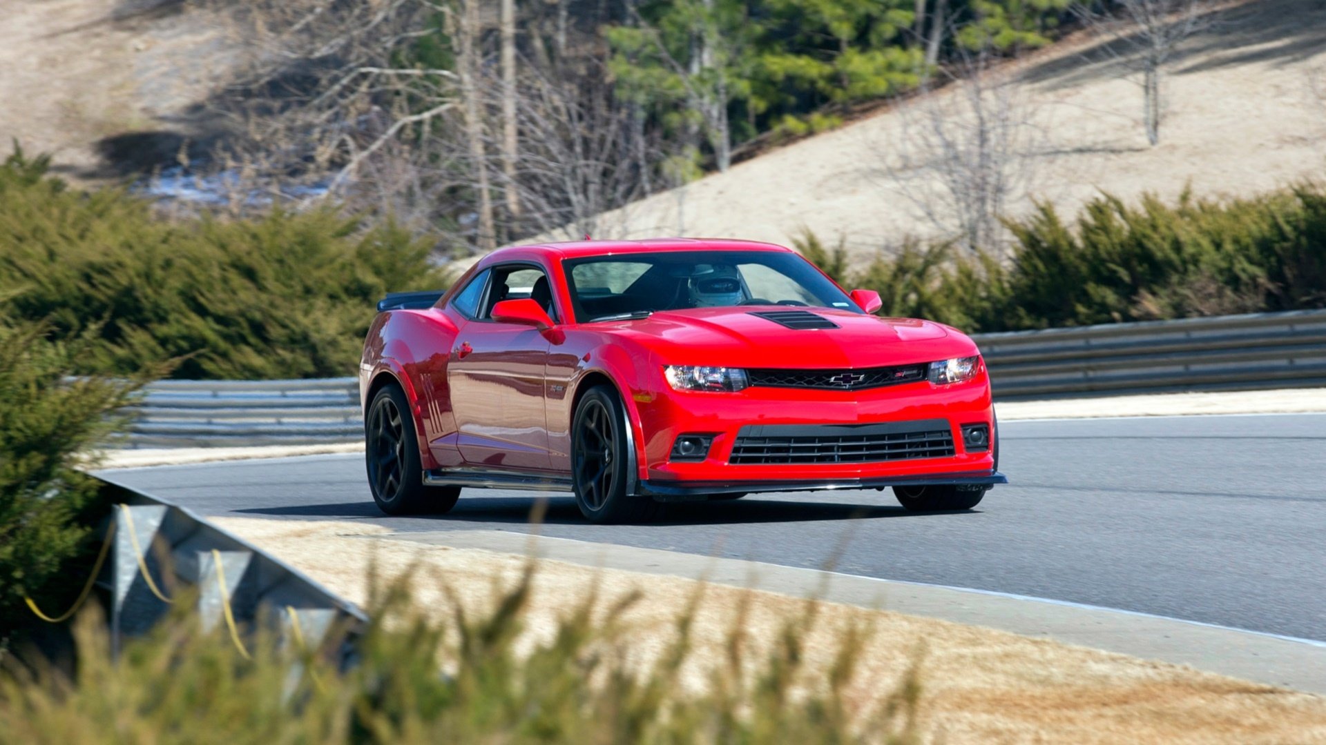 A red Chevrolet Camaro Z28 speeding on a racetrack, captured in high definition as a PC desktop wallpaper and background.