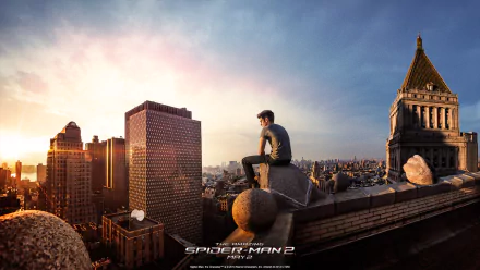 HD wallpaper showing Andrew Garfield as Peter Parker in The Amazing Spider-Man 2, sitting atop a New York City skyscraper, gazing over the cityscape during sunset.