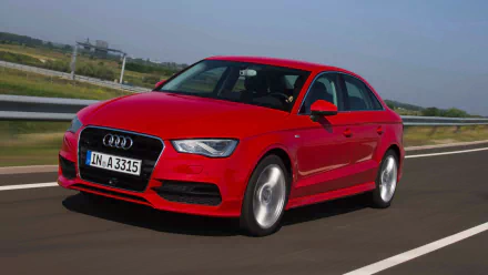 HD PC desktop wallpaper featuring a red Audi A3 driving on a highway with a clear sky and green landscape in the background.