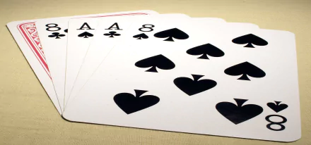 A high-definition desktop wallpaper featuring playing cards, focusing on eight spade cards arranged in a fan, showcasing a bold and striking design.