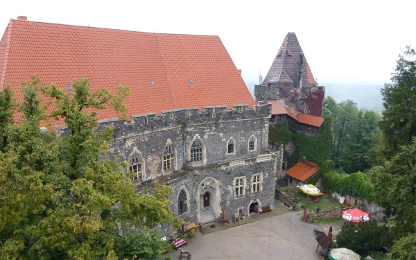 Man-made Grodziec Castle on a hilltop with red roofs and stone façade, shown as a 2K Quad HD PC desktop wallpaper and background.