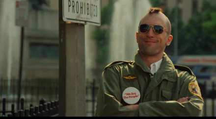 A striking HD desktop wallpaper featuring Robert De Niro as Travis Bickle in Taxi Driver, showcasing his iconic look with a mohawk, sunglasses, and defiant expression.