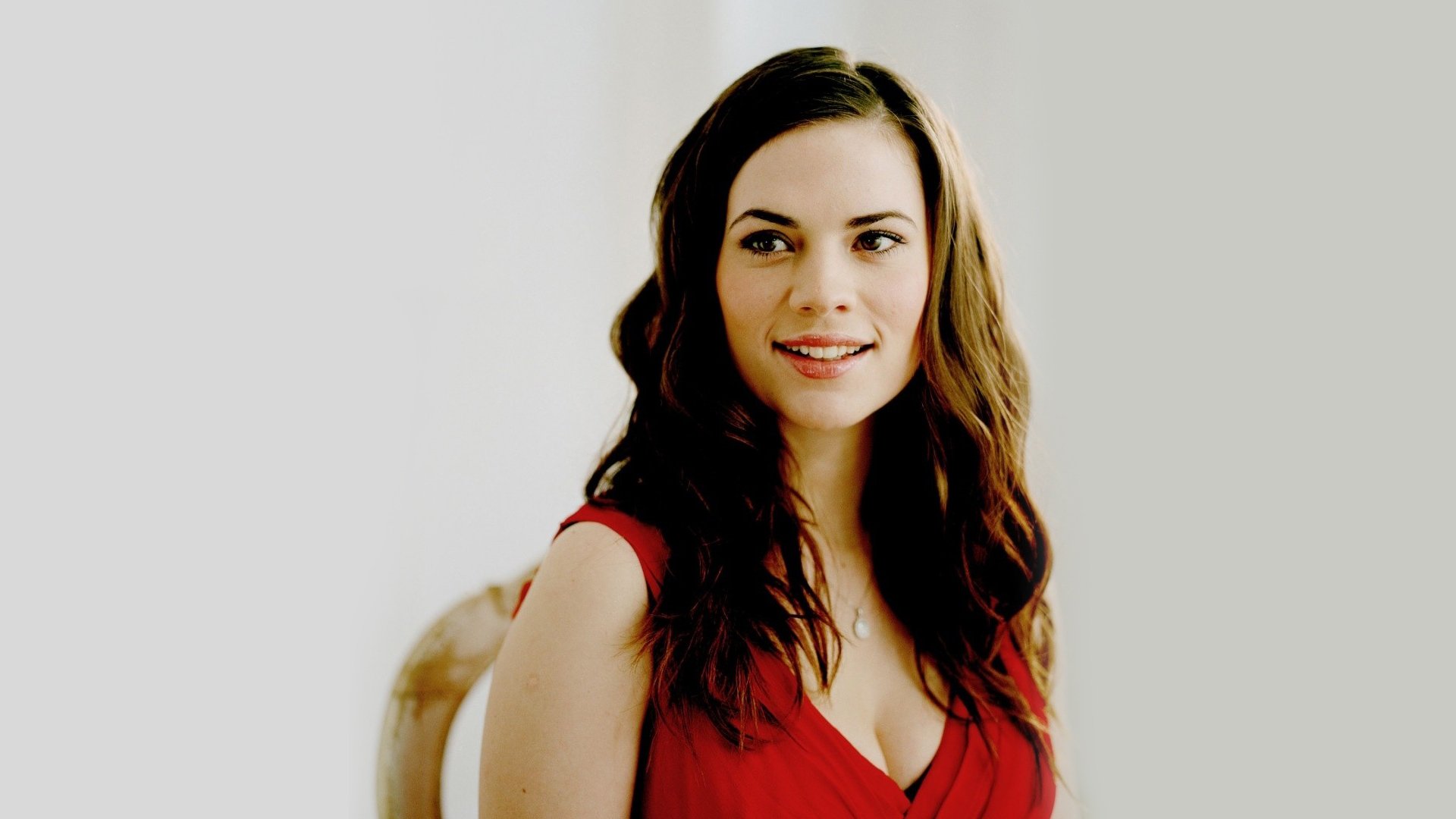 HD PC desktop wallpaper of an English actress in a red dress smiling against a soft, pale background.