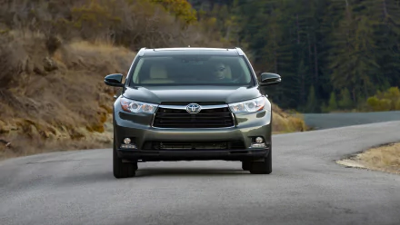 Front view of a Toyota Highlander Hybrid SUV on a winding rural road, HD PC desktop wallpaper/background.