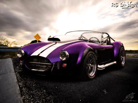 HD desktop wallpaper featuring a sleek purple AC Shelby Cobra with white racing stripes under a dramatic cloudy sky.