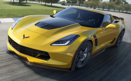 HD PC desktop wallpaper featuring a sleek yellow Chevrolet Corvette speeding on a road with a green park and trees in the background.