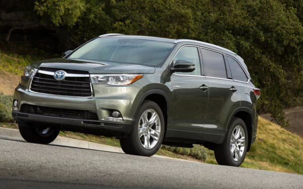 Vehicle: Toyota Highlander Hybrid SUV on a roadside slope with trees; HD PC desktop wallpaper and background.