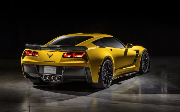 Gold Chevrolet Corvette Z06 sports car rear three-quarter view on dark reflective floor — high-resolution 2K Quad HD PC desktop wallpaper and vehicle background.