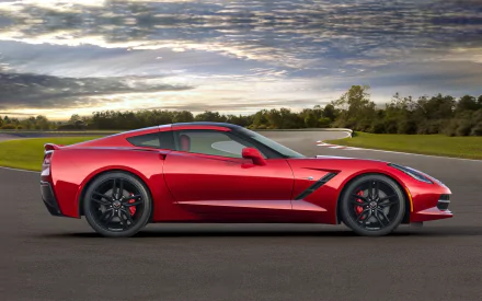 Red Chevrolet Corvette Stingray parked on a racetrack under a dramatic cloudy sky, captured in high-definition for a PC desktop wallpaper.