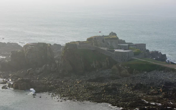 Aerial view of Fort Clonque, a historic man-made structure perched on rocky cliffs, surrounded by the sea, offering a captivating backdrop for a HD PC desktop wallpaper.