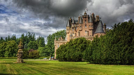HD desktop wallpaper featuring the man-made Glamis Castle set against dramatic cloudy skies and surrounded by lush greenery.