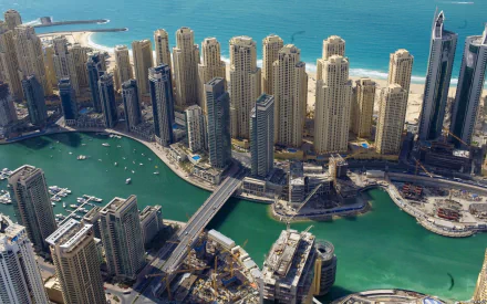 Aerial view of Dubai Marina cityscape with turquoise canal, towering man-made skyscrapers and bridges along the coastline — HD PC desktop wallpaper and background.