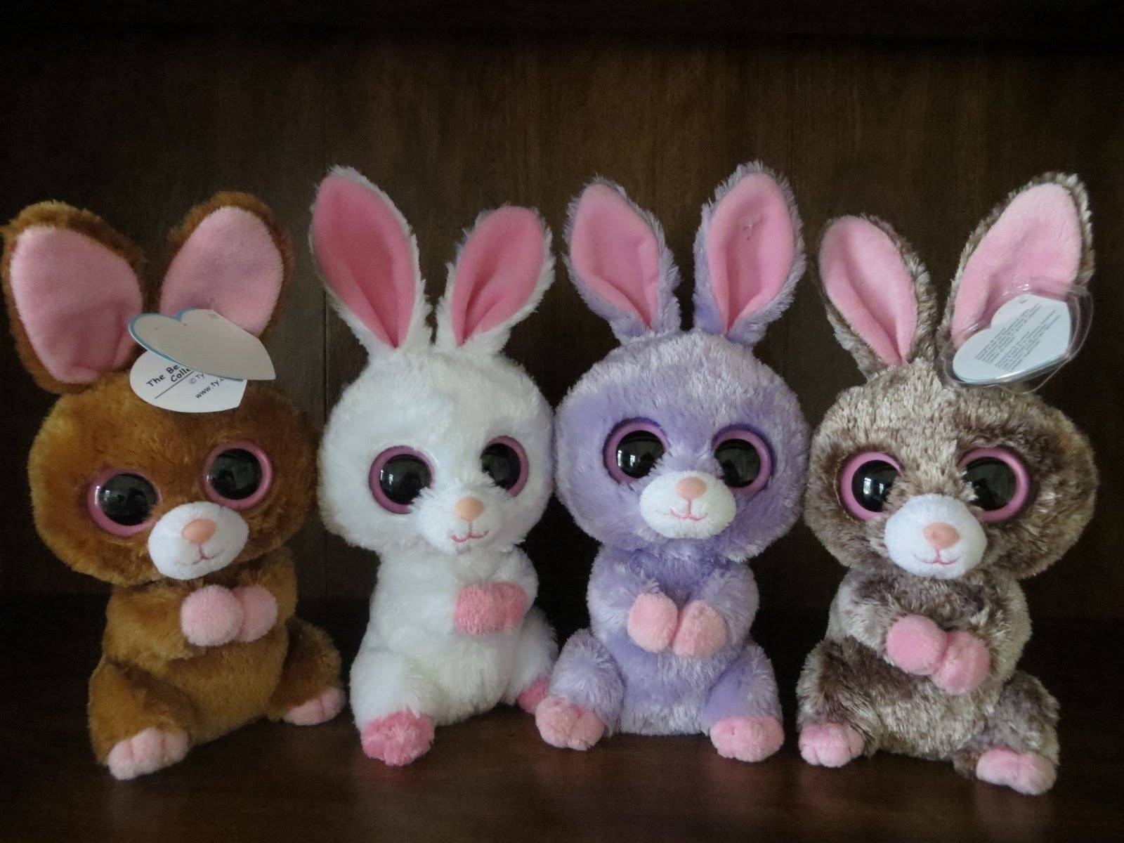 HD desktop wallpaper featuring a collection of man-made Beanie Boos plush toys, including bunnies and a small brown animal, displayed against a dark background.