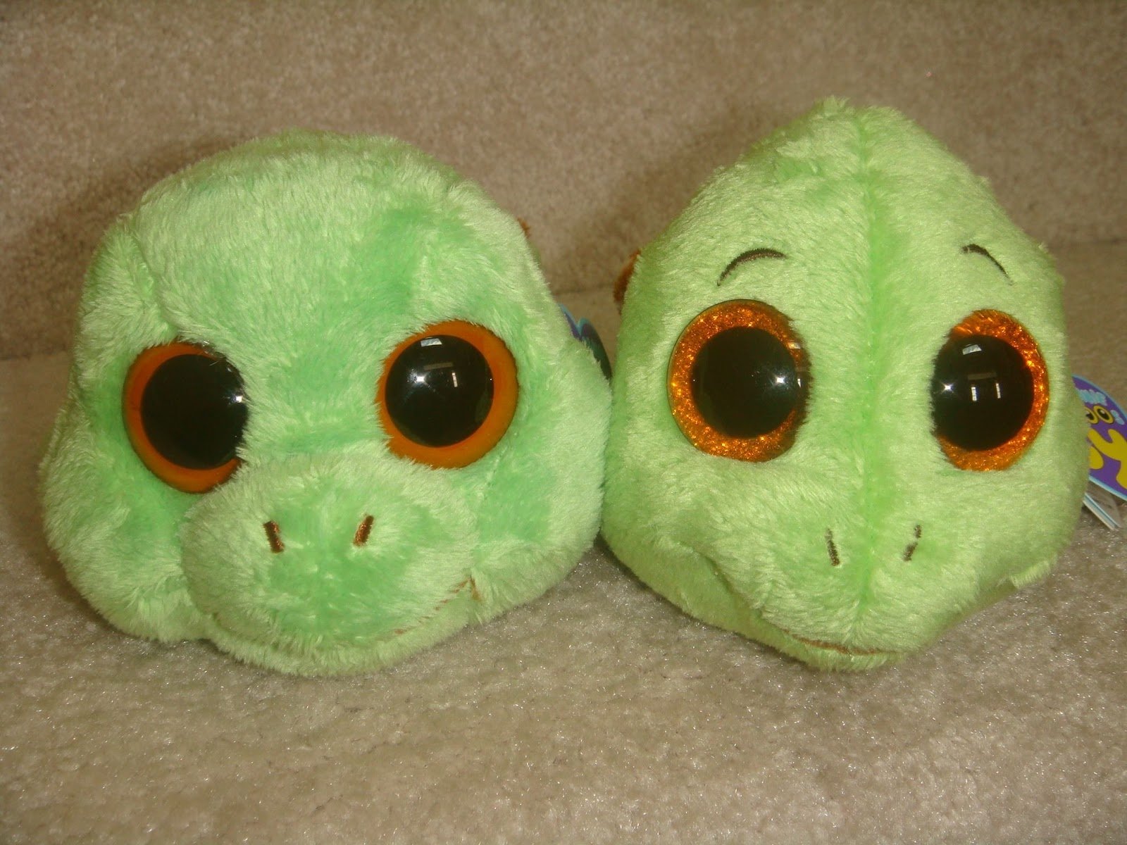 HD desktop wallpaper featuring two green Beanie Boos with large orange-rimmed eyes, showcasing their soft, plush man-made design.