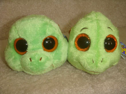 HD desktop wallpaper featuring two green Beanie Boos with large orange-rimmed eyes, showcasing their soft, plush man-made design.