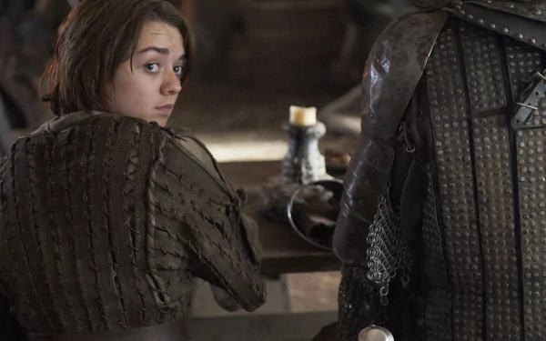High-resolution 4K Ultra HD wallpaper featuring Maisie Williams as Arya Stark from the TV show Game of Thrones, capturing a tense moment in medieval attire.