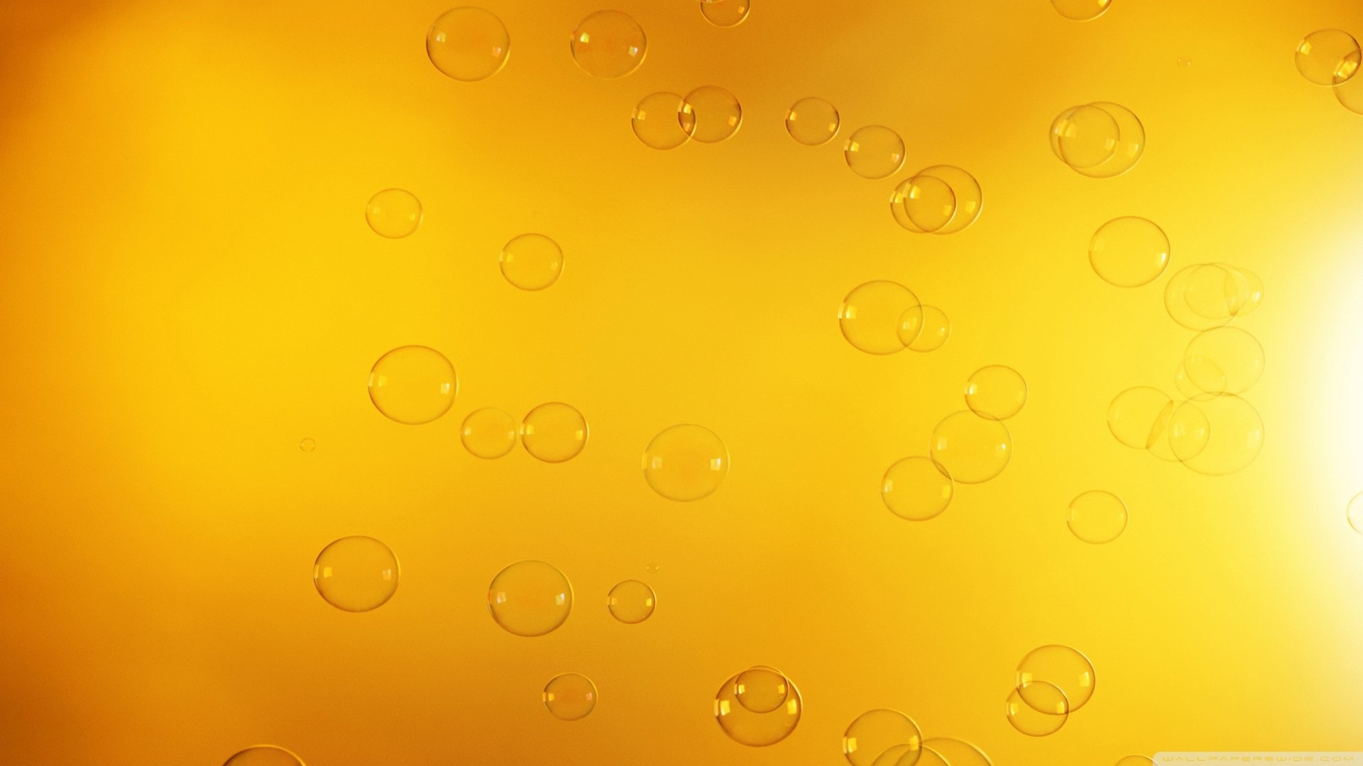 Abstract HD desktop wallpaper featuring shimmering bubbles against a warm yellow background, creating a vibrant and dynamic visual atmosphere.