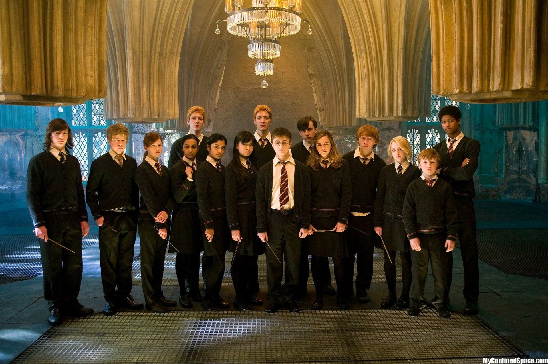 A dramatic scene from Harry Potter and the Order of the Phoenix, featuring a group of young wizards standing together in a grand, illuminated hall. Suitable as an HD PC desktop wallpaper.