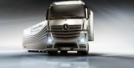 4K Ultra HD desktop wallpaper featuring a sleek Mercedes-Benz Actros truck with illuminated headlights and a modern trailer against a smooth, reflective background.
