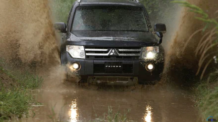 Mitsubishi Pajero driving through muddy water, captured in an HD PC desktop wallpaper showcasing the vehicle's rugged off-road capability.