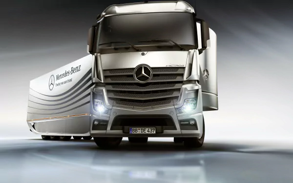 4K Ultra HD desktop wallpaper featuring a sleek Mercedes-Benz Actros truck with illuminated headlights and a modern trailer against a smooth, reflective background.