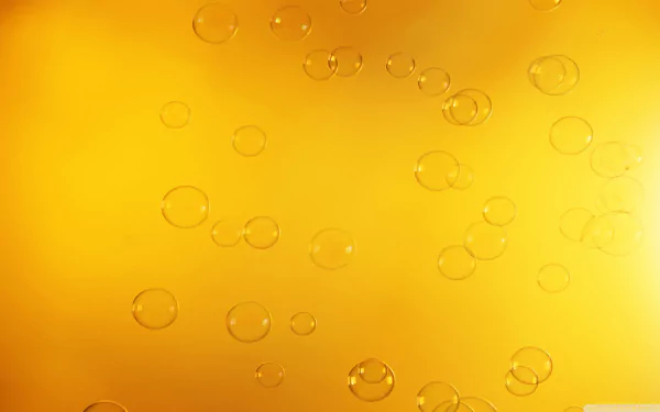 Abstract HD desktop wallpaper featuring shimmering bubbles against a warm yellow background, creating a vibrant and dynamic visual atmosphere.