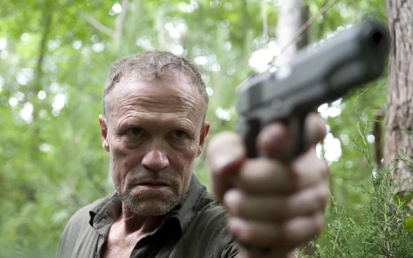 Merle Dixon from *The Walking Dead* aims a handgun confidently in a dense forest, showcasing the intense atmosphere of the TV show's post-apocalyptic world.