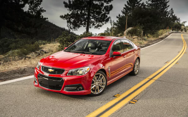 Red Chevrolet SS sedan parked on a winding mountain road — Chevrolet vehicle rendered as a 2K Quad HD PC desktop wallpaper and background.
