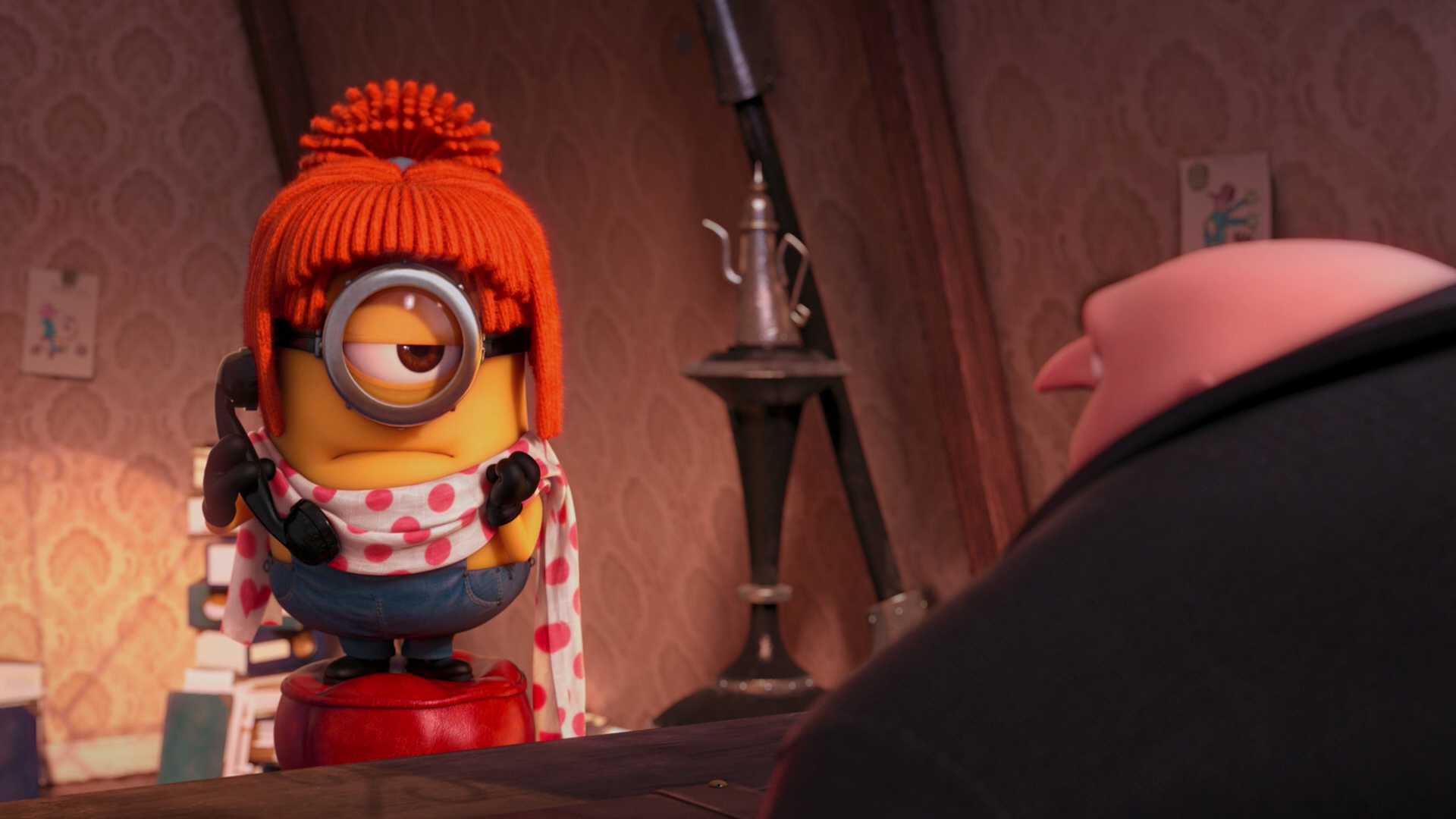 HD desktop wallpaper from Despicable Me 2 featuring a Minion wearing a red hat and scarf, interacting with Gru in a warm, indoor setting.