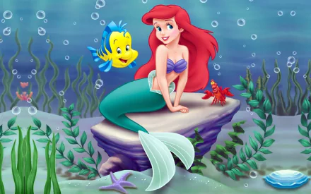 Ariel, the red-haired mermaid from Disney's The Little Mermaid, poses on a rock with Flounder and Sebastian, surrounded by underwater plants and bubbles in this vibrant HD wallpaper.