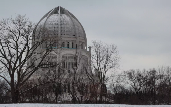Religious Baha'i temple dome framed by bare winter trees under a gray sky — HD PC desktop wallpaper/background.