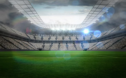 A vibrant HD sports stadium wallpaper featuring a green field, illuminated by bright lights, under a dramatic sky. Ideal for enhancing your PC desktop background.