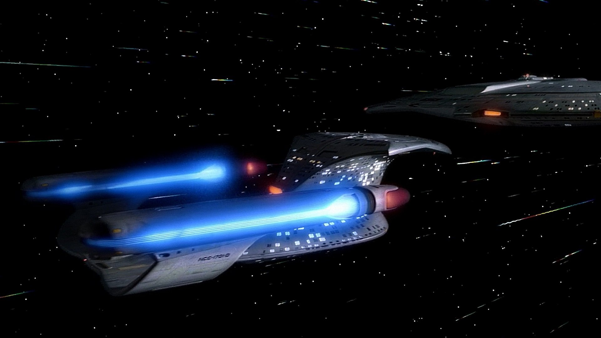 HD PC desktop wallpaper showcasing a Star Trek: The Next Generation starship flying through space with glowing blue warp engines.