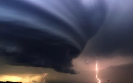 A dramatic HD wallpaper capturing a powerful tornado formation with swirling clouds and striking lightning, showcasing the awe-inspiring beauty of nature's storms.
