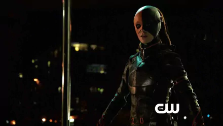 HD desktop wallpaper featuring a character from the TV show Arrow, dressed in dark tactical gear with a half-mask, set against a nighttime urban backdrop.