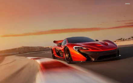 A striking McLaren P1 showcases its sleek design as it races around a track, set against a vibrant sunset. This HD image captures the essence of performance and elegance in automotive design.